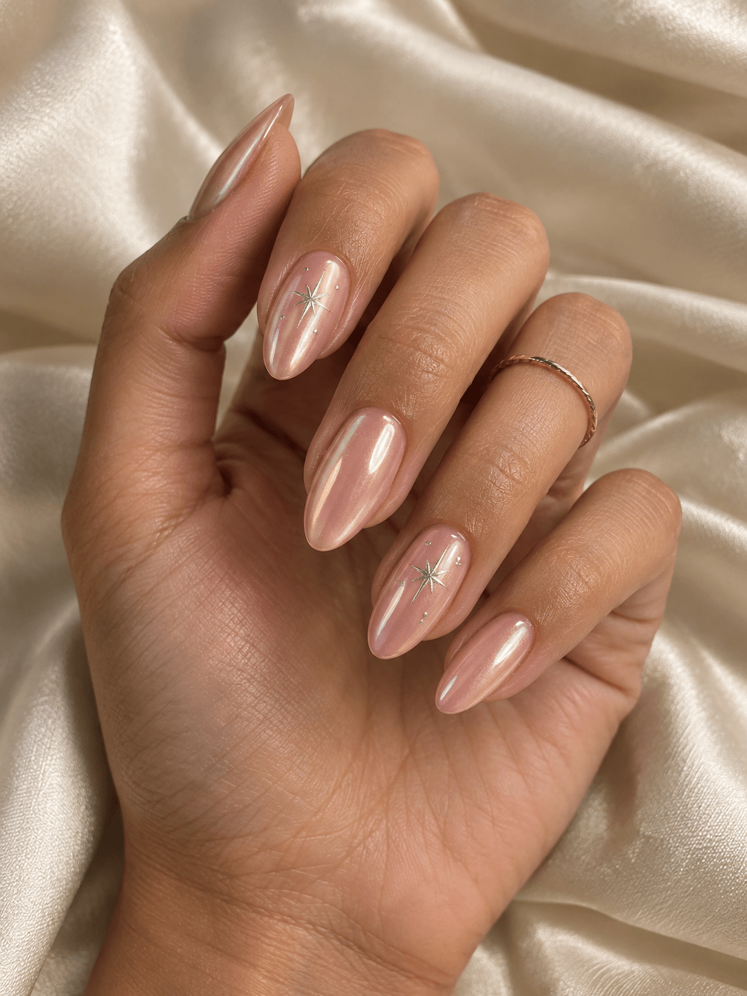 Blush chrome almond nail design with silver star details